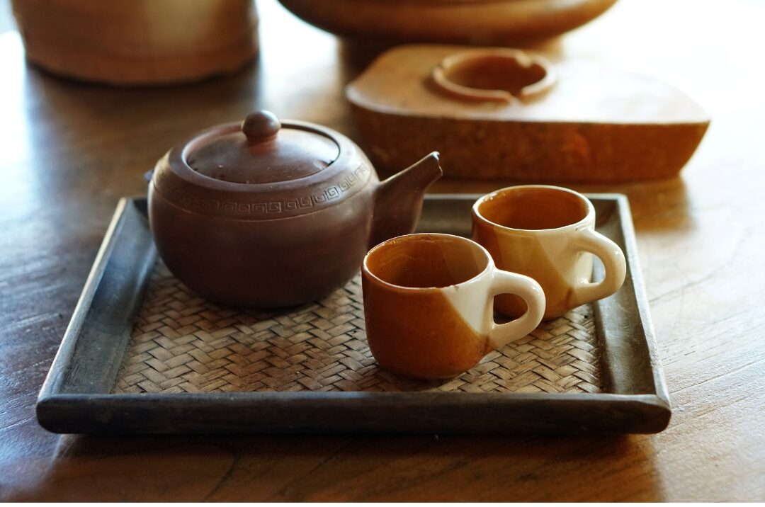 ceramic teapot and matching cups set neatly on a wooden tray