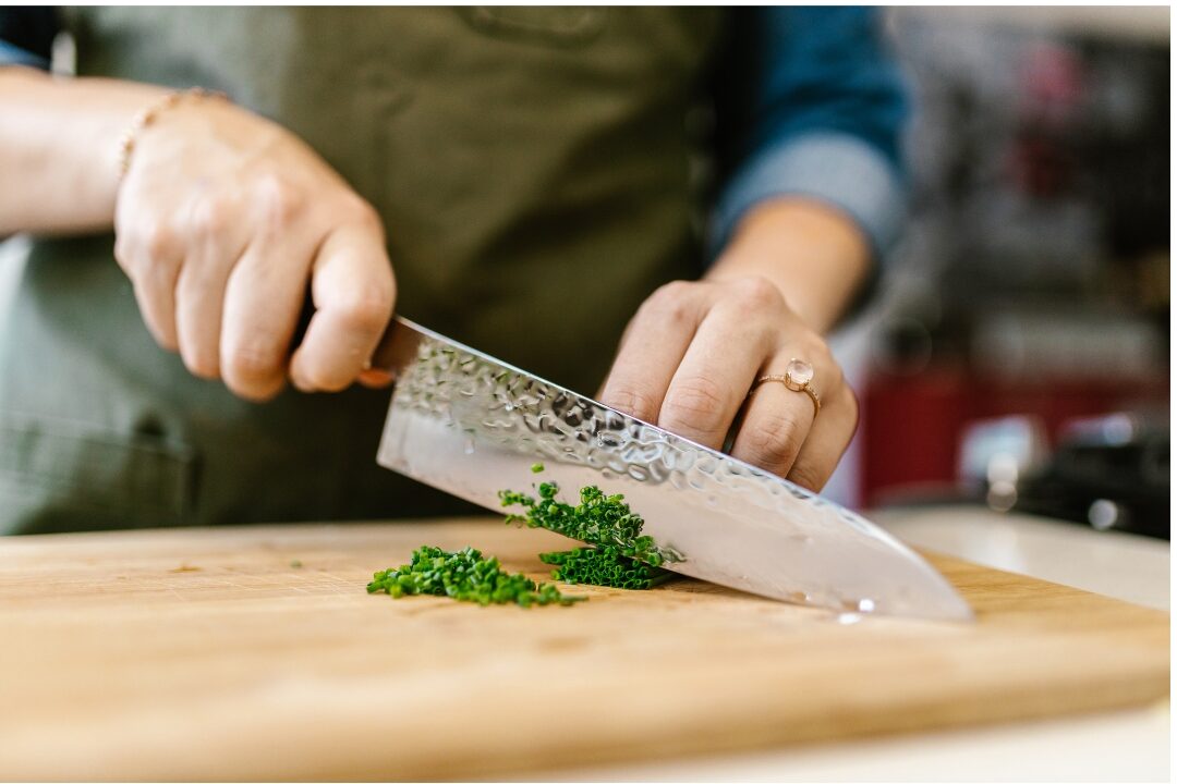 sharp chef knife on cutting board exploring 50 things to stop buying to save money