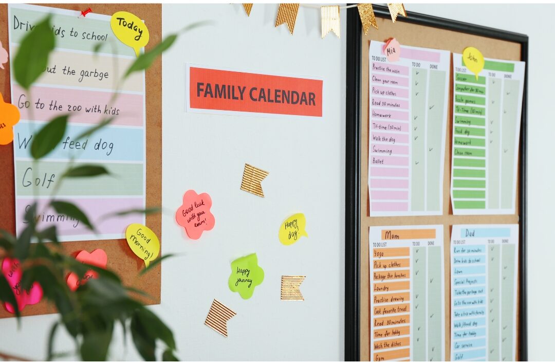 family calendar board hanging on wall with color coded notes offloading mental weight