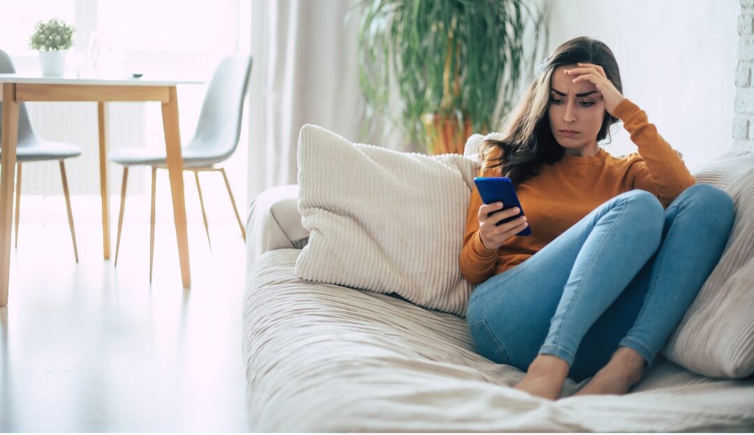 woman looking thoughtfully at smartphone while resting on sofa breaking highlight reel comparison