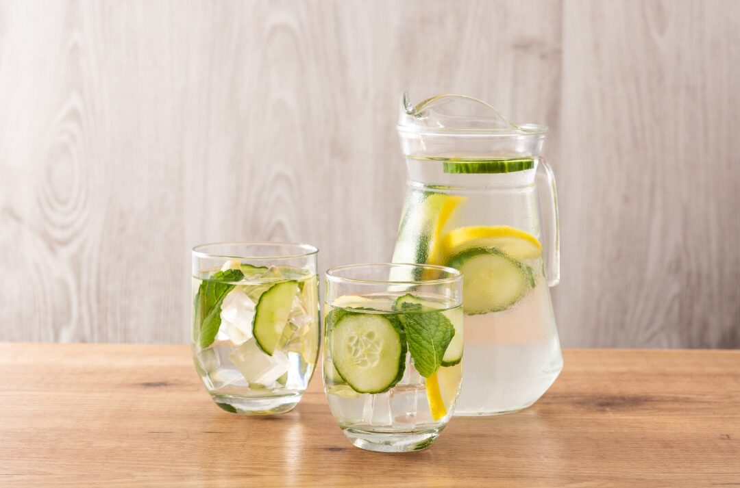 clear glass water pitcher filled with cucumber slices and fresh mint featuring 30 tiny luxuries every woman deserves