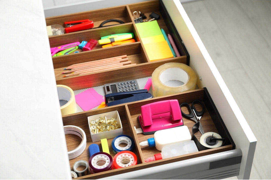 neat desk drawer organized with wooden compartments for pens and clips