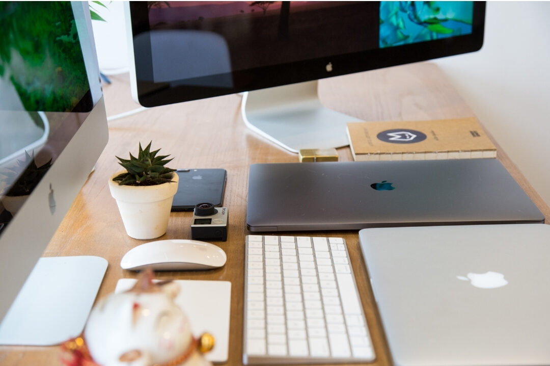 smartphone sitting face down beside wooden laptop desk in bright room reducing digital alerts