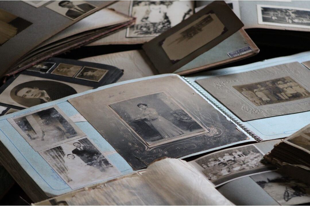 open vintage photo album with handwritten notes on wooden desk reviewing 35 things wealthy families do differently