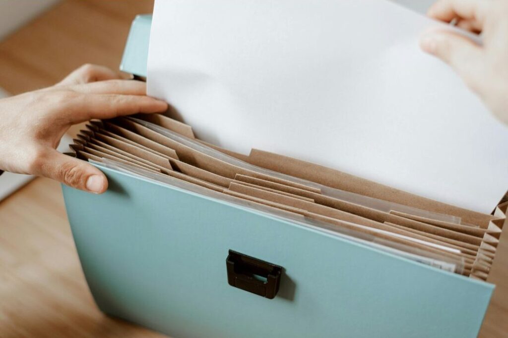 hand organizing financial documents establishing baseline income and overhead