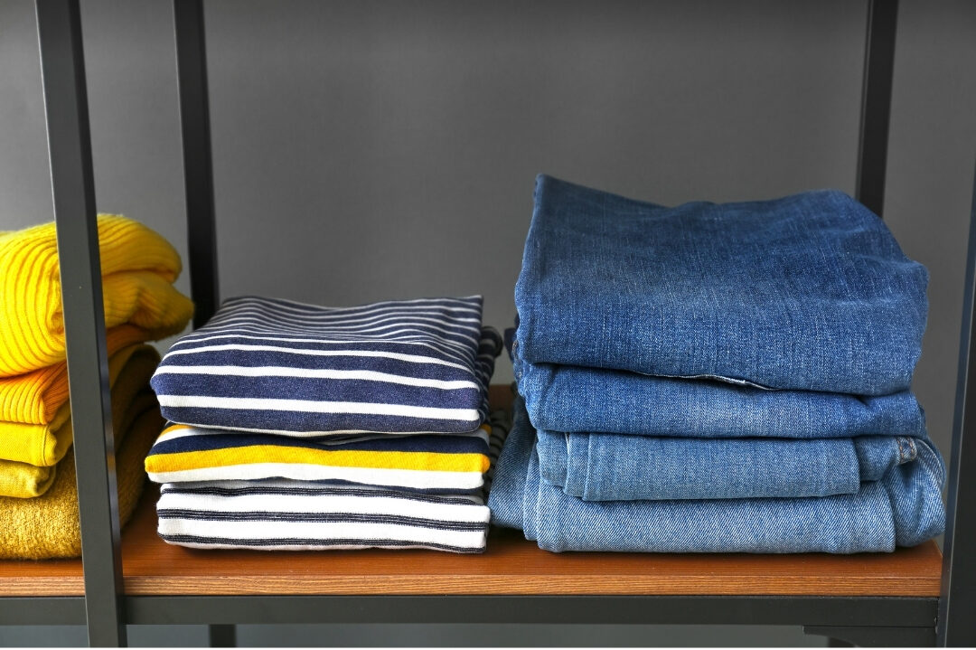 neatly folded denim jeans stacked on a clean closet shelf