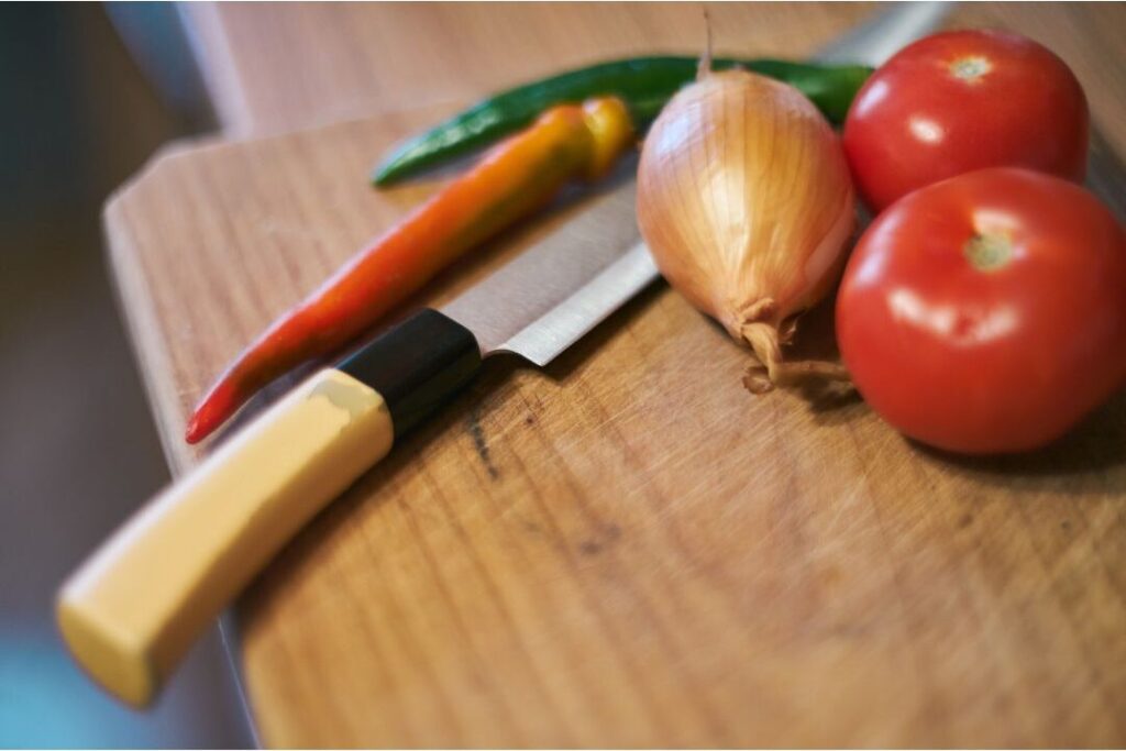fresh whole vegetables on cutting board representing frugal kitchen choices