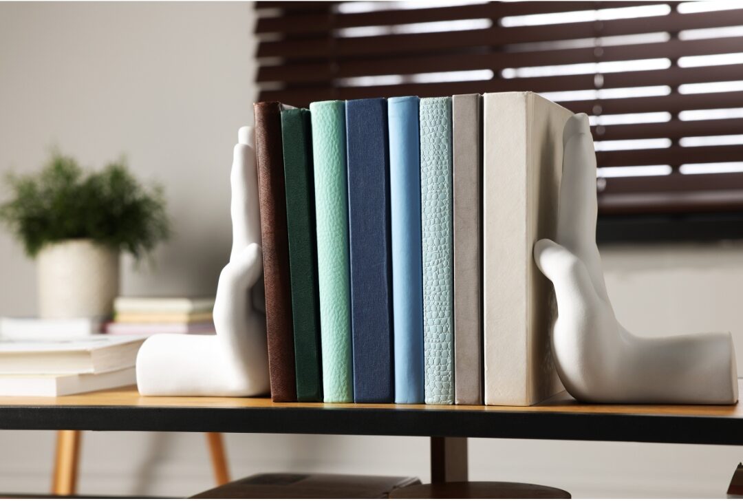 heavy marble bookends holding a row of books on a wooden shelf