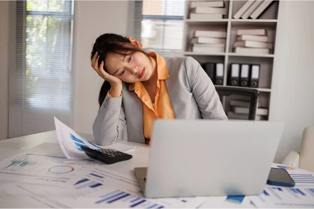 woman resting head gently against hands at sunlit table understanding nervous system fatigue