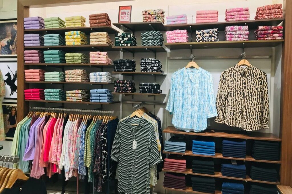 stacks of kids clothes showing consumer spending habits that keep families broke