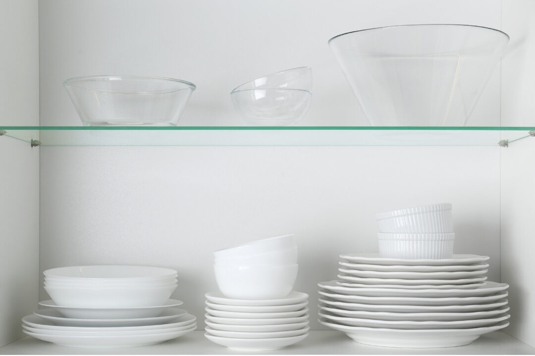 organized kitchen cabinet showing stacked clean white ceramic plates