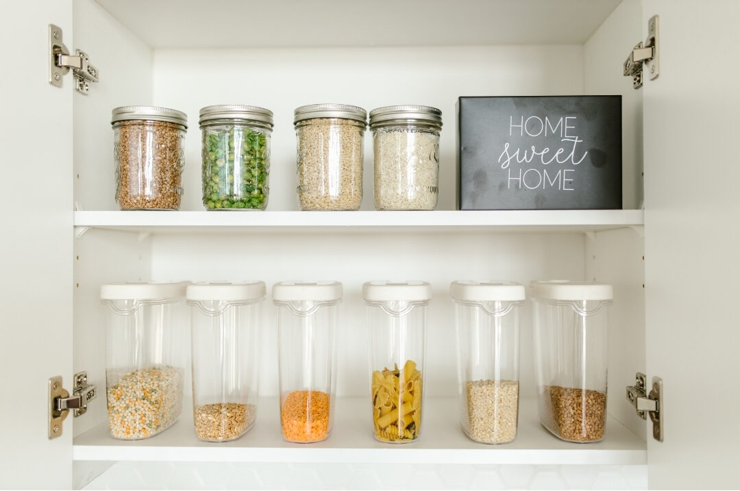 tidy kitchen pantry with neatly organized glass jars on wooden shelves