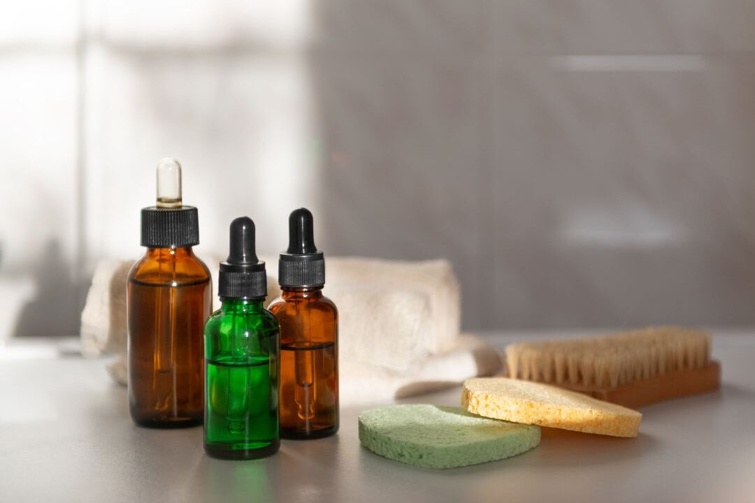 "amber glass bottle with body oil on marble bathroom shelf featuring 60 soft life ideas every mom should try
