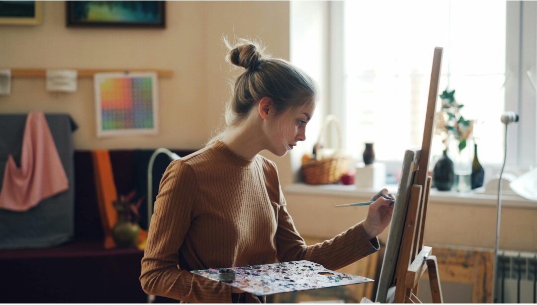 woman painting on canvas in cozy sunlit room reclaiming creative identity