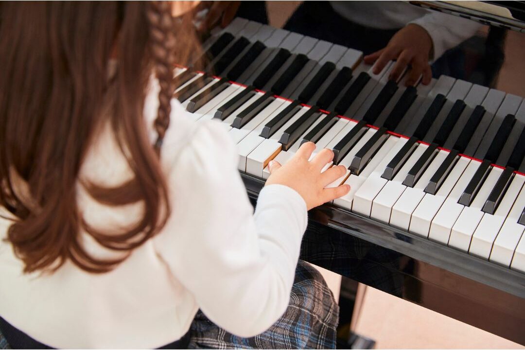 person focused on mastering grand piano sheet music in warm light