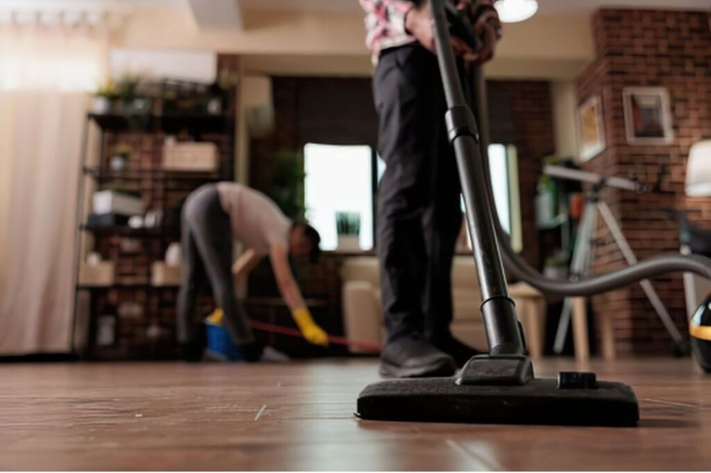 hand picking up stray items off hardwood living room floor