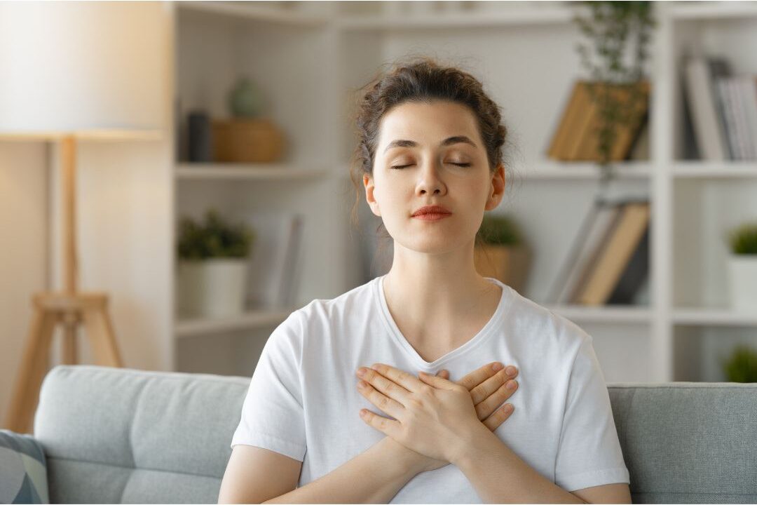woman closing her eyes peacefully on sofa
