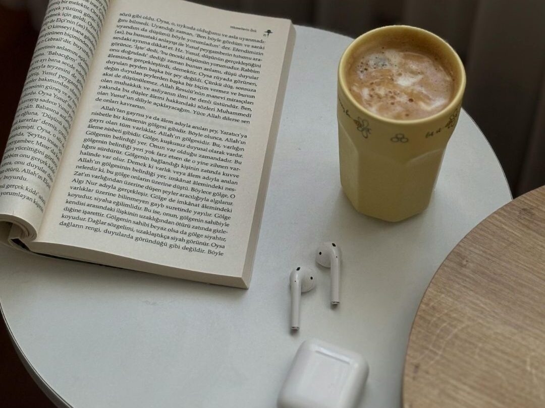 wireless earbuds resting next to coffee cup on kitchen counter