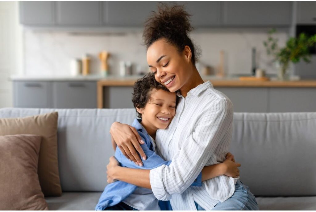 mother smiling warm hugging young child revealing why successful moms don't start their day with laundry