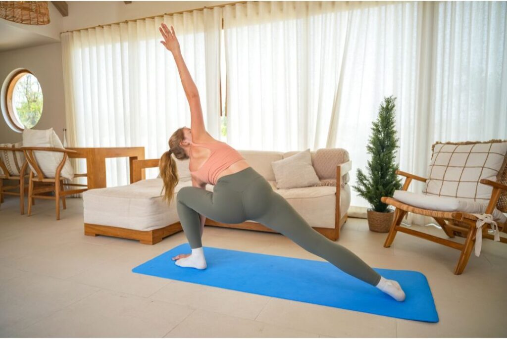 woman stretching quietly on yoga mat in serene sunlit room