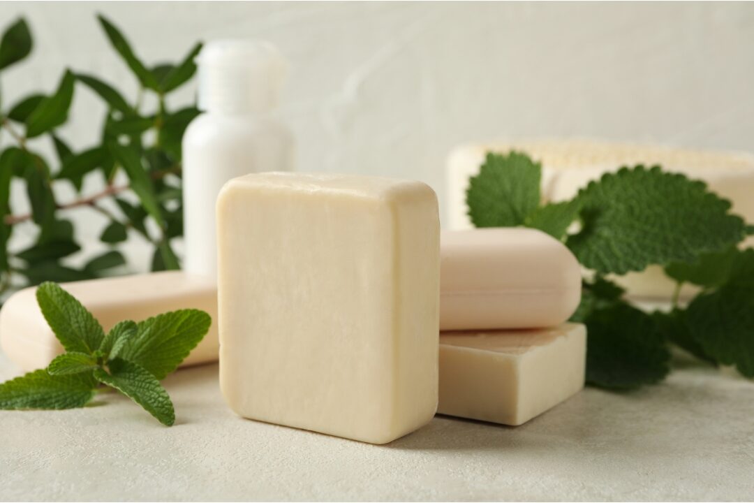 bars of natural soap resting on wooden soap dish