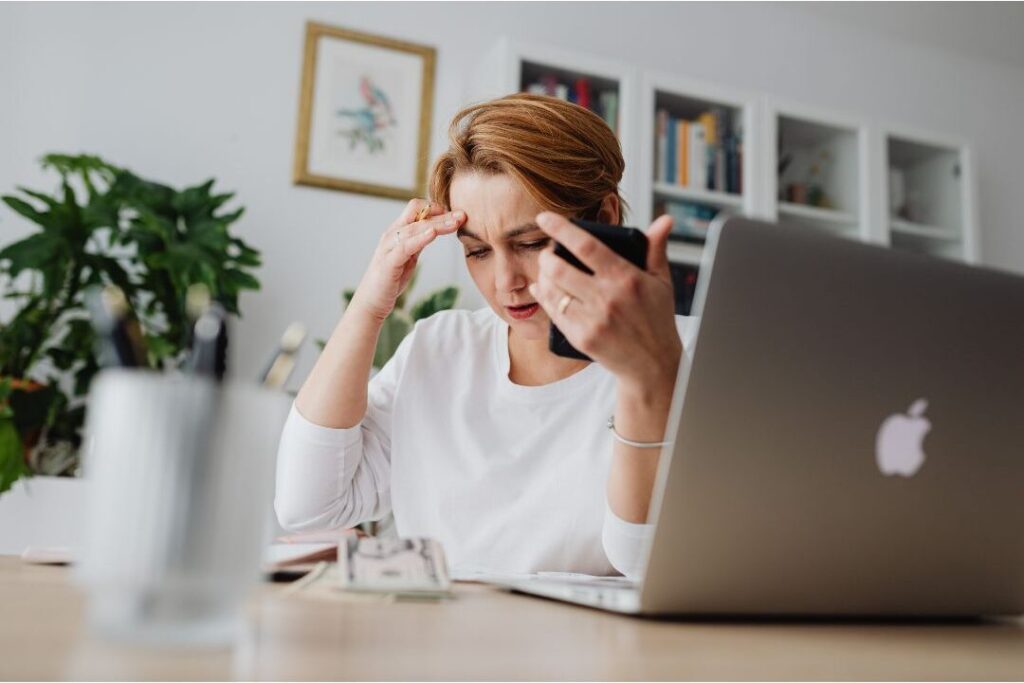 person reviewing monthly bills at desk to lower expenses