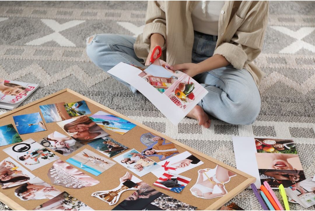 family cutting magazine pictures and pasting onto poster boards on floor