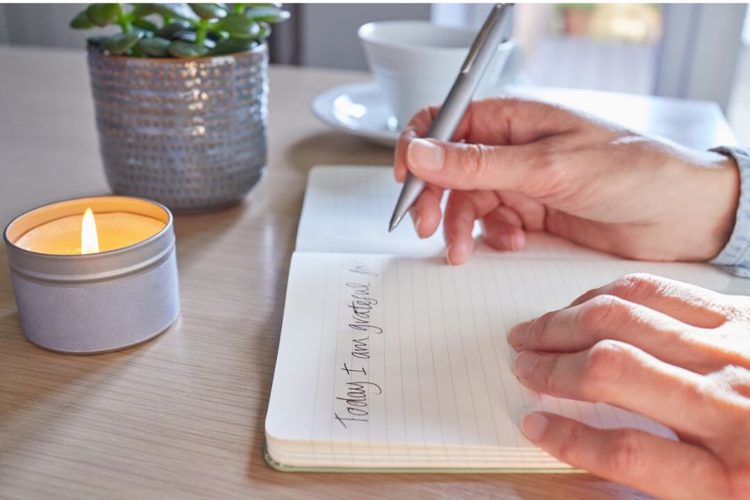 woman writing in journal with soft bedside warm lighting exploring 60 soft life ideas every mom should try