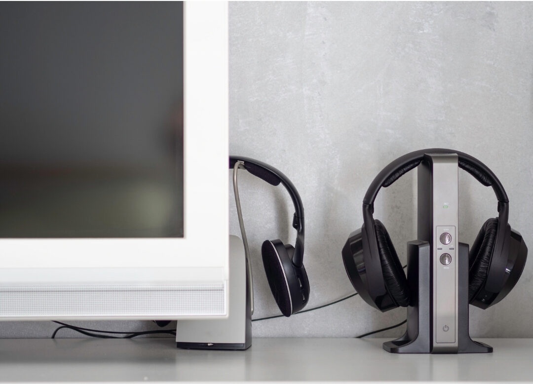 over ear wireless noise canceling headphones resting beside laptop on desk managing ambient noise