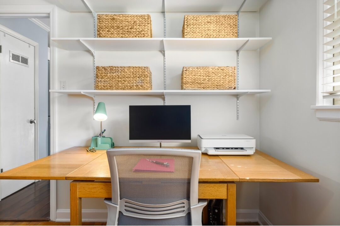 organized office bookshelf with neat storage boxes and framed desk art