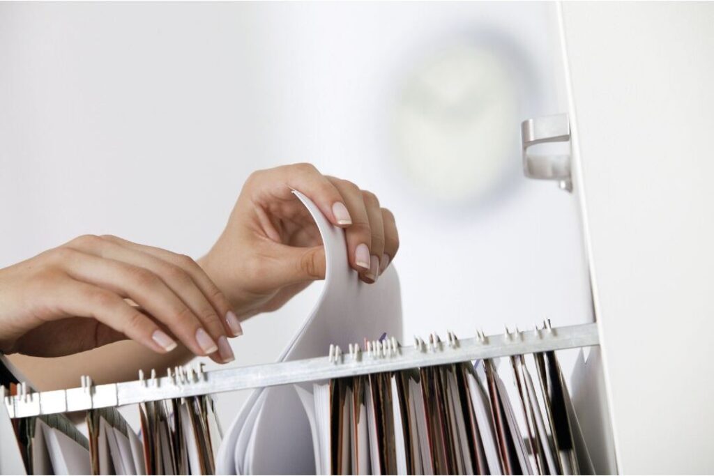 woman placing incoming paper mail directly into desktop filing box presenting the home reset trick that changed My entire week