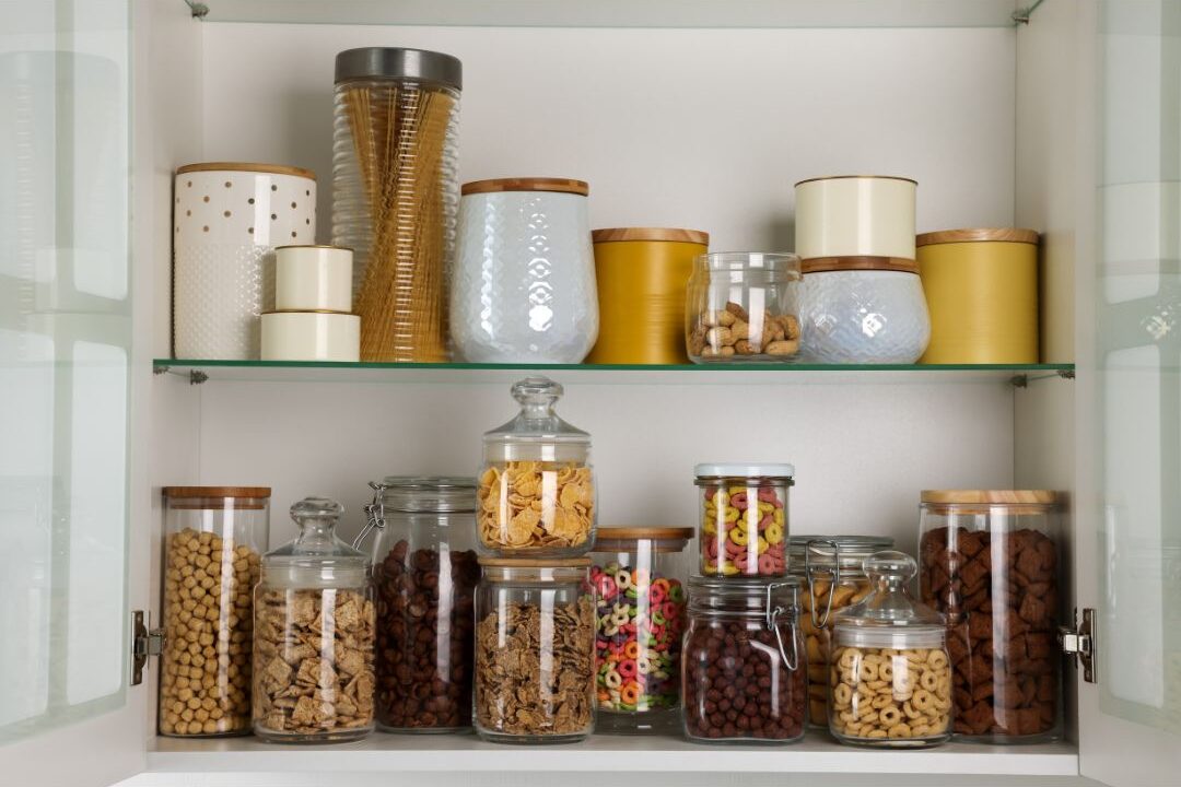 organized pantry shelves filled with glass jars and matching containers