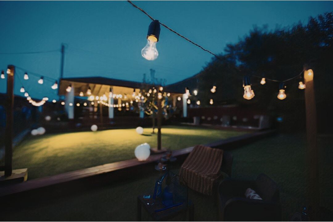 outdoor bistro string lights crisscrossing cozy outdoor patio at dusk showcasing 70 budget-friendly home upgrades that are actually worth it