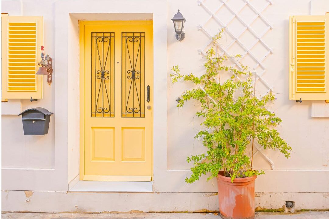 bright yellow front door on classic home with dark exterior walls