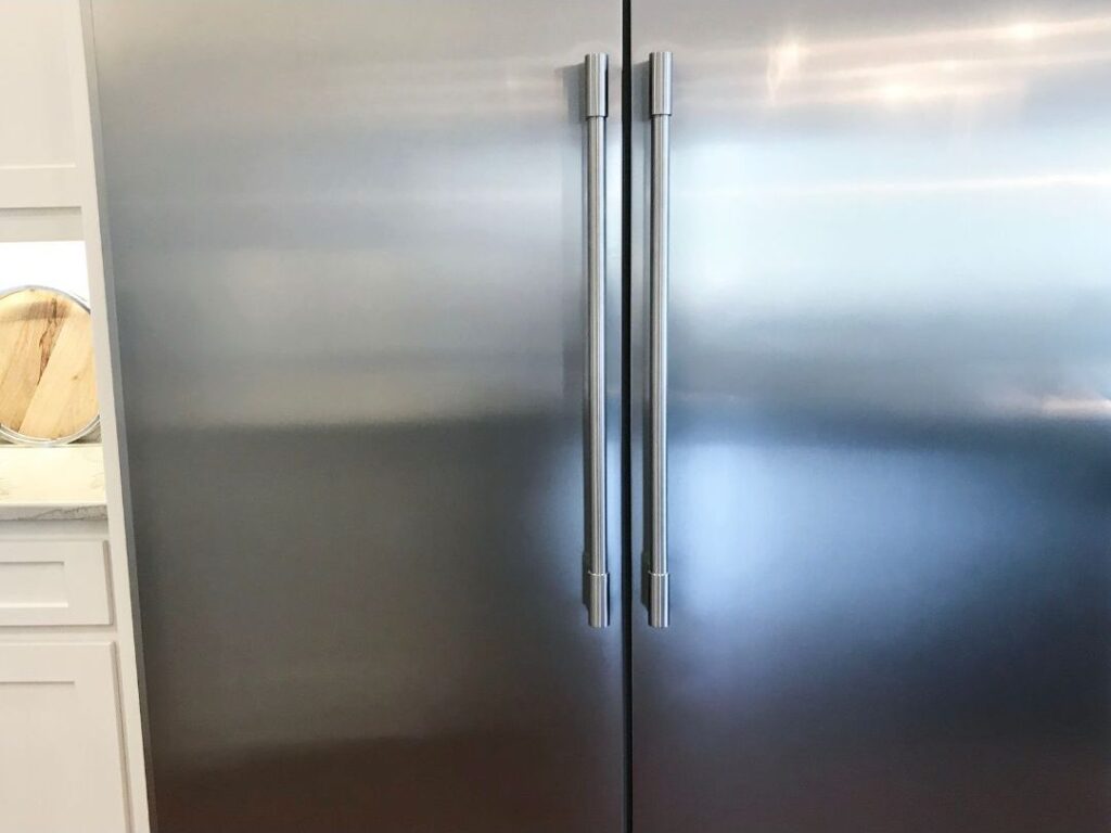 clean stainless steel refrigerator door showing how these 10 things quietly make your house feel chaotic