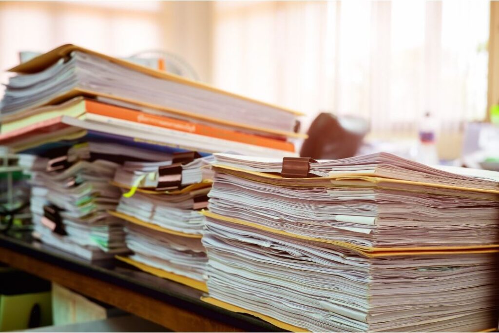 open shelf with messy stacks of paper mail and bills