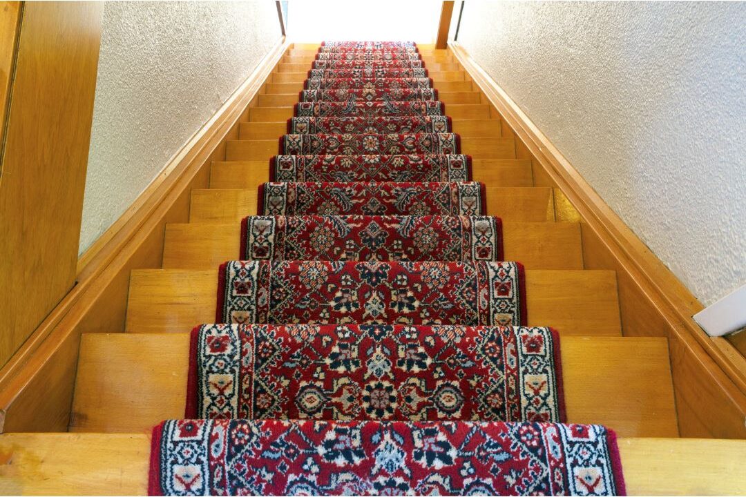 patterned stair runner rug secured with brass rods on wooden stairs