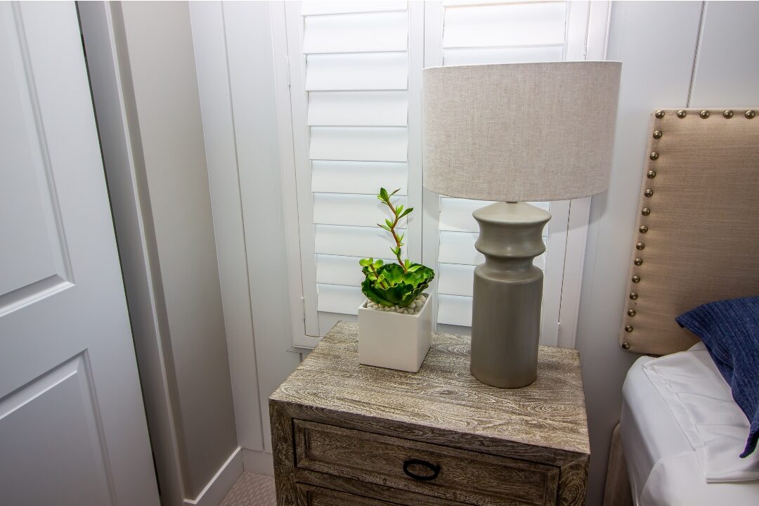 peaceful bedroom nightstand with ceramic lamp and small plant