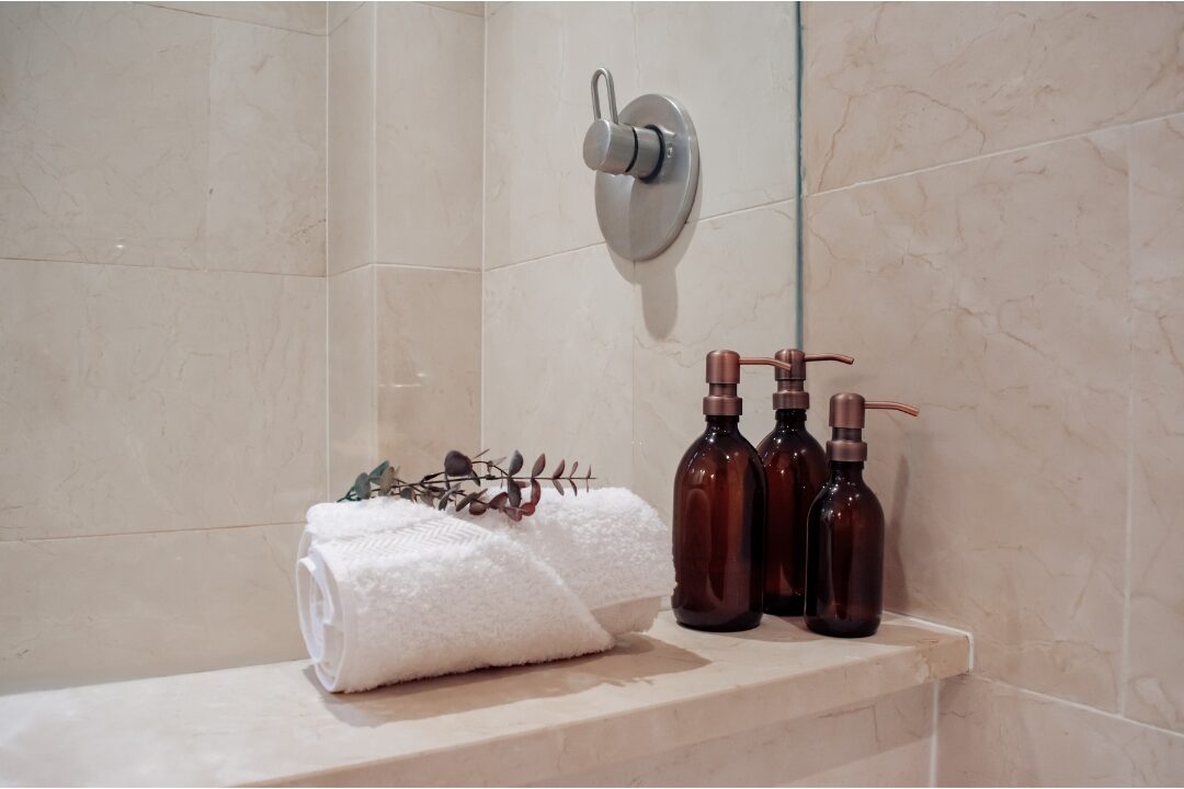 clean bathroom counter with simple amber skincare glass bottles