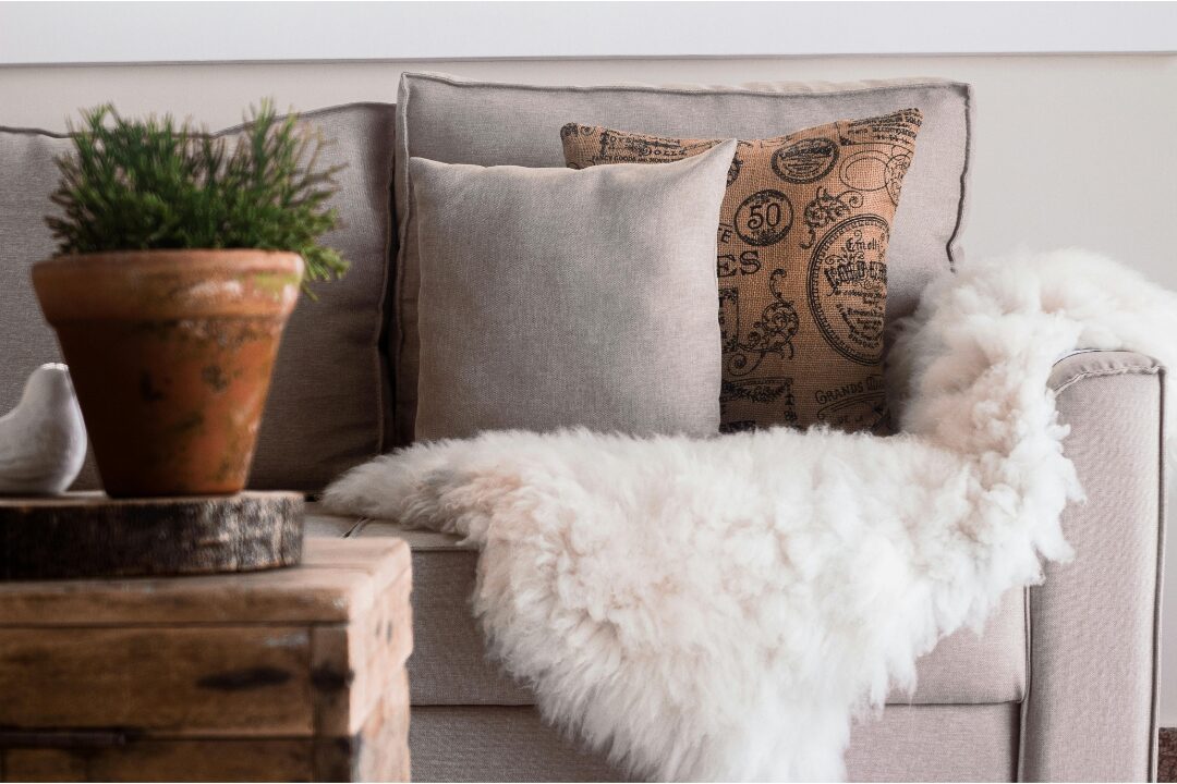 deep plush sofa overflowing with large neutral accent cushions and throws