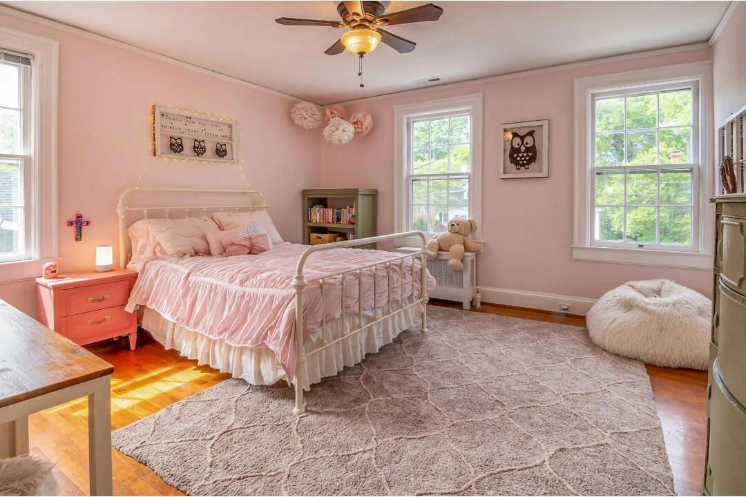 soft white sheepskin rug lying beside wooden bed frame on hardwood floor