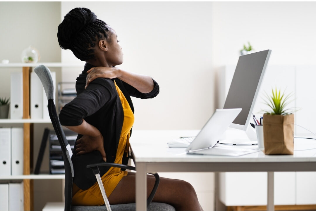woman sitting with perfect ergonomic posture at bright home office desk maintaining comfortable workspace