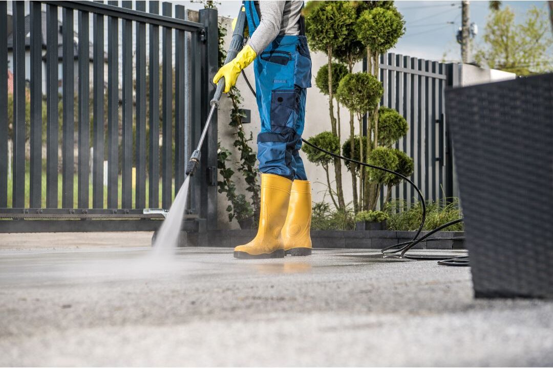 pressure washer cleaning dirty concrete driveway revealing bright surface