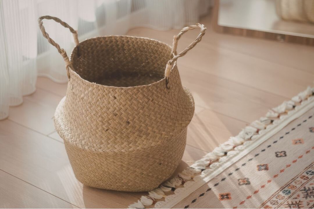 stylish woven rattan storage basket sitting on hardwood floor featuring 45 daily habits that make life easier