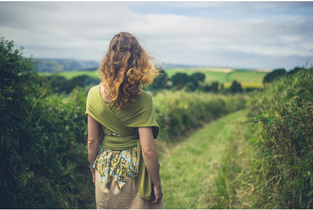 woman walking peacefully along sunlit garden path with calm posture taking control of time