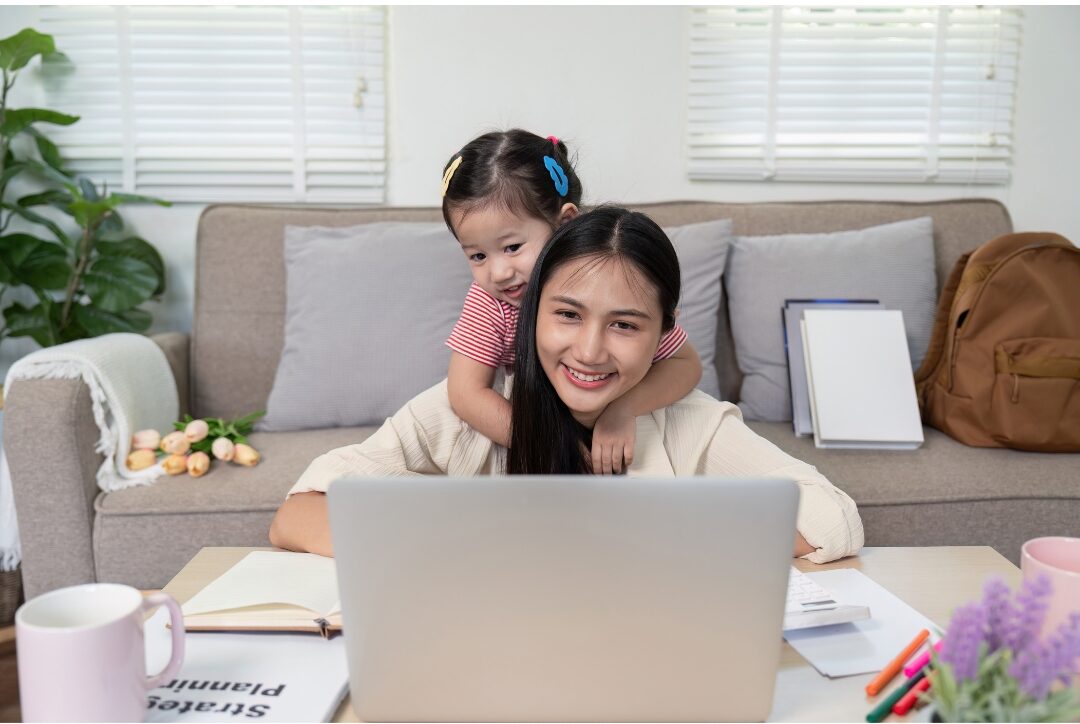 mother sharing a happy moment with child while working at home desk dismantling beliefs that keep moms playing small