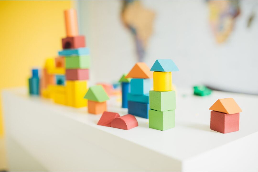 child toy wooden blocks left neatly beside soft rug