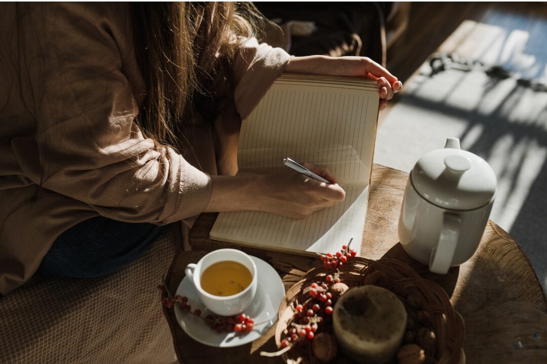 woman reviewing financial budget on notebook calmly with warm tea realizing why comparison is stealing your joy