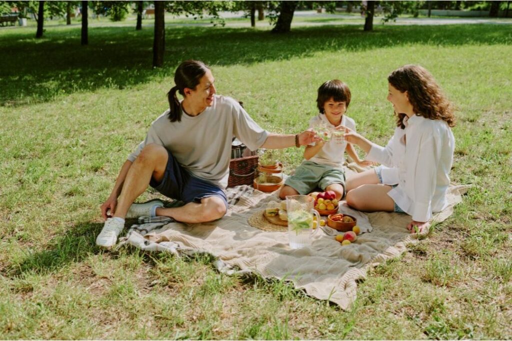 mother enjoying peaceful park picnic representing restorative self-care and family joy bucket