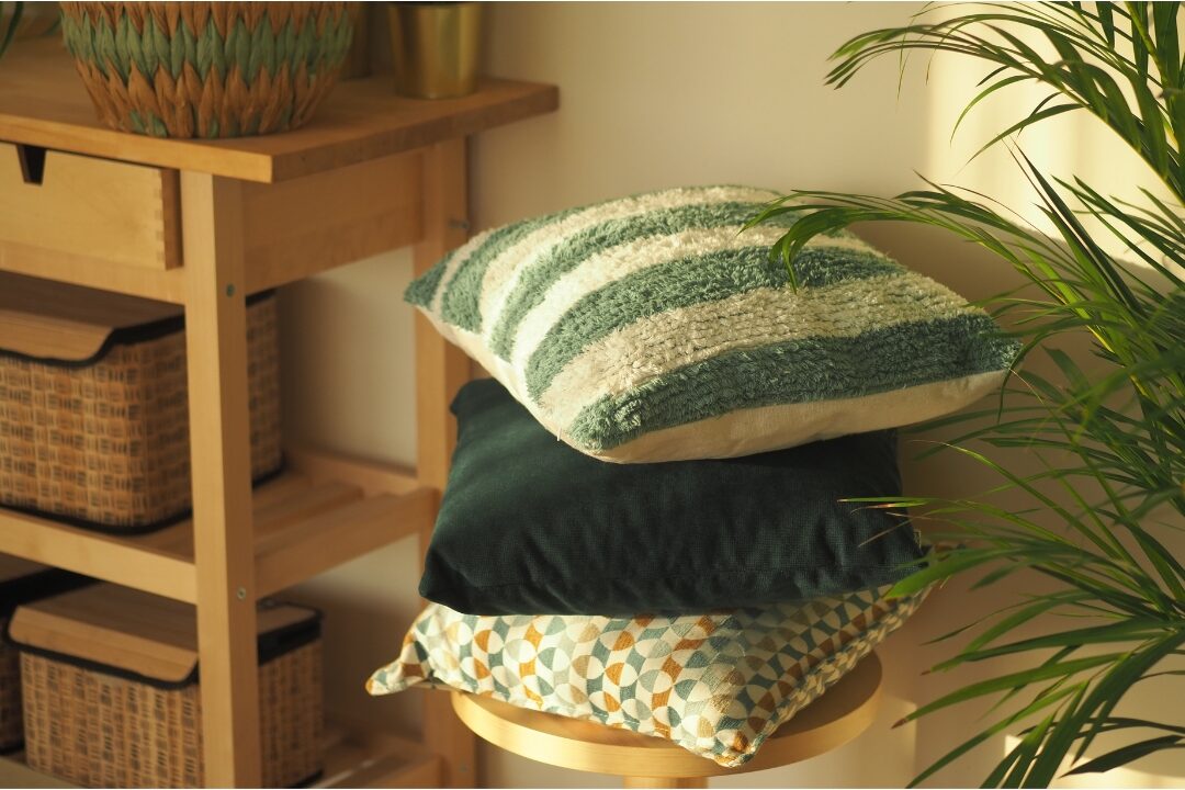 quiet corner with floor cushion, small wooden stool, and potted plant